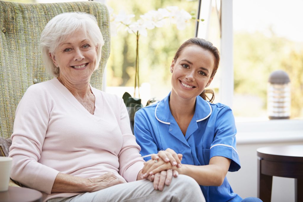 Senior woman sitting with Caregiver in retirement home